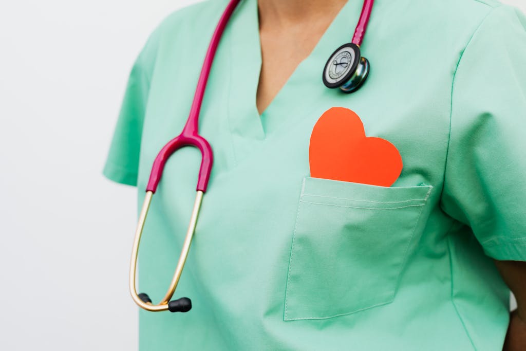 photo by photo by: kaboompics.com A healthcare professional with a stethoscope and red heart symbol emphasizes cardiology care.