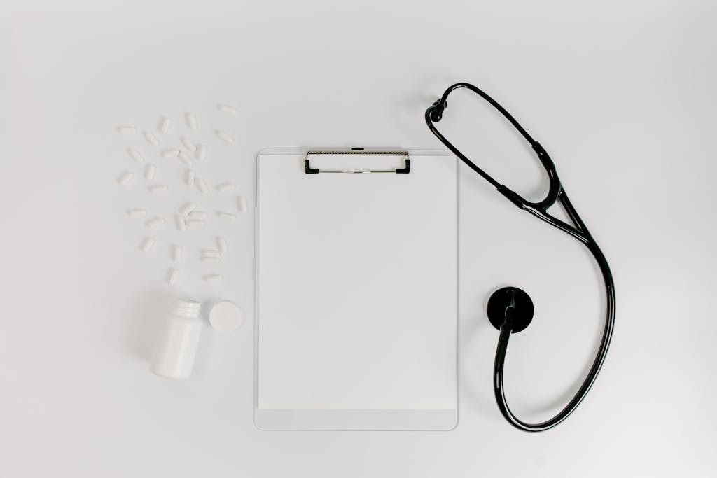 photo by tara winstead Flat lay of clipboard, pills, and stethoscope for medical use.